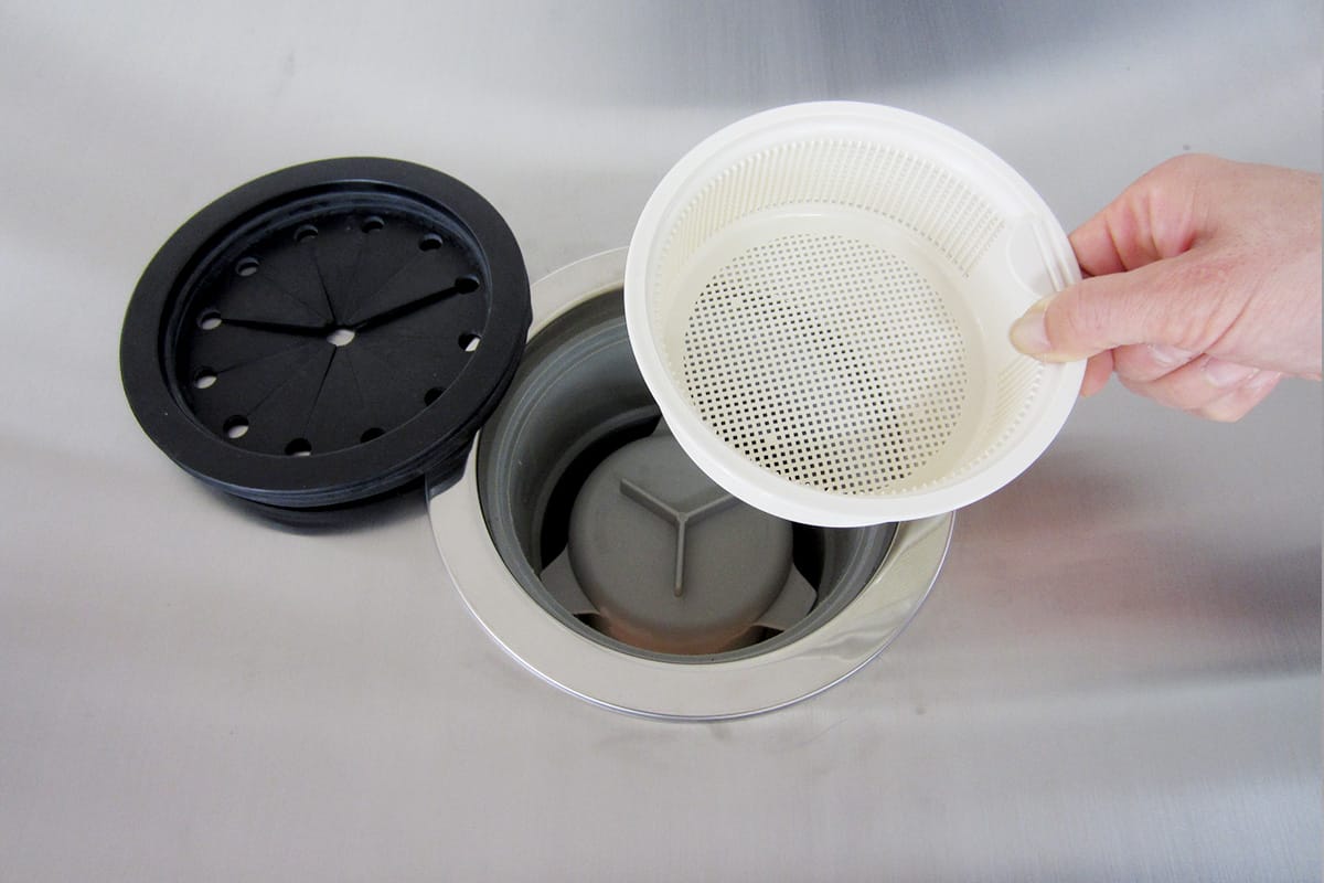 使用中の排水口ごみ受けを取り外す様子