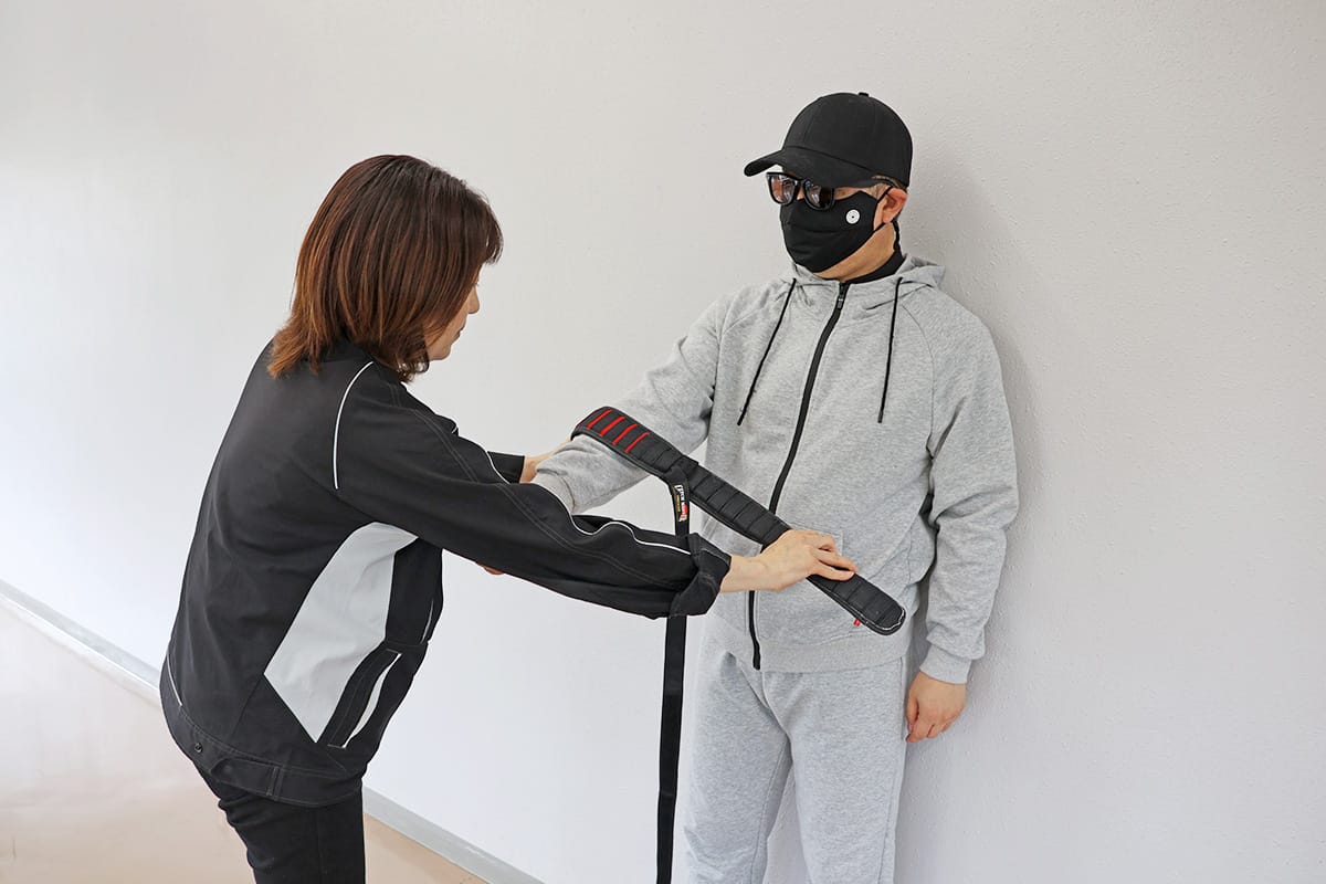 オロチSO7を不審者に叩きつけずゆっくり押し当てて巻きつける様子